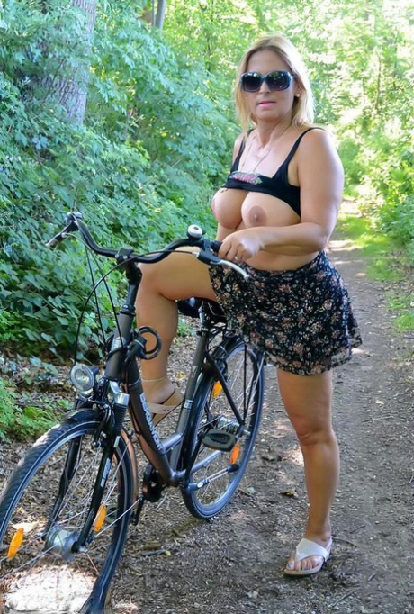 Busty plump mature Chrissy bicycling topless with her huge big boobs swaying