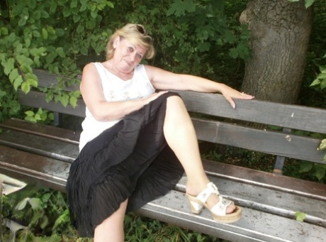 Mature amateur whore Caro masturbating on the bench in the woods