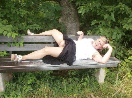 Mature amateur whore Caro masturbating on the bench in the woods