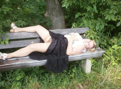 Mature amateur whore Caro masturbating on the bench in the woods