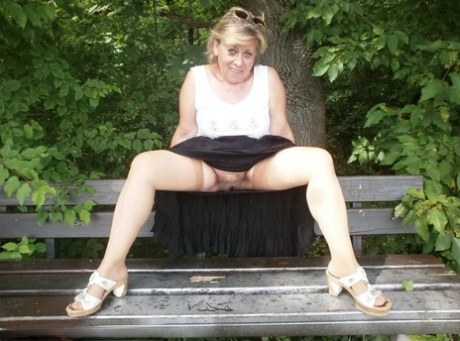 Mature amateur whore Caro masturbating on the bench in the woods