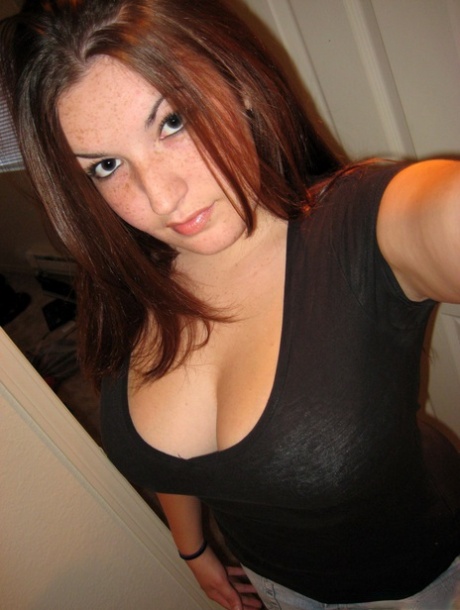 Amateur girl licks her lips while lifting up her shirt during self shot action