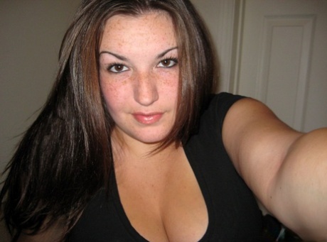 Amateur girl licks her lips while lifting up her shirt during self shot action