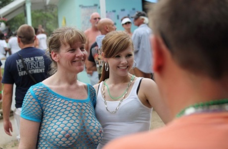Amateur girls and strippers get naked on an outdoor stage at an adult event