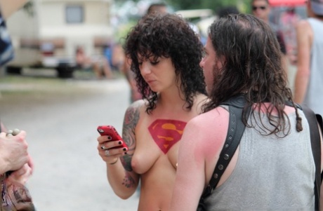 Amateur girls and strippers get naked on an outdoor stage at an adult event