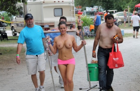 Amateur girls and strippers get naked on an outdoor stage at an adult event