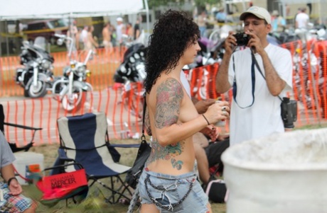 Amateur girls and strippers get naked on an outdoor stage at an adult event