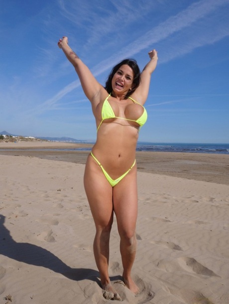Curvy girl Chloe Lamour sets her big fake tits free of a bikini at the beach