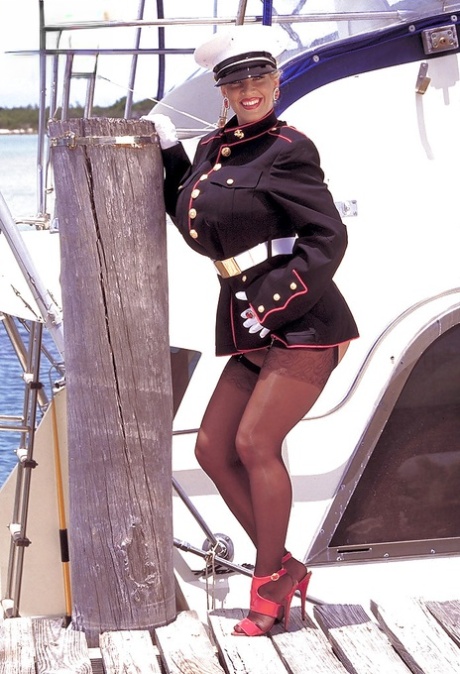 Older blonde babe Busty Dusty freeing huge boobs from uniform outdoors