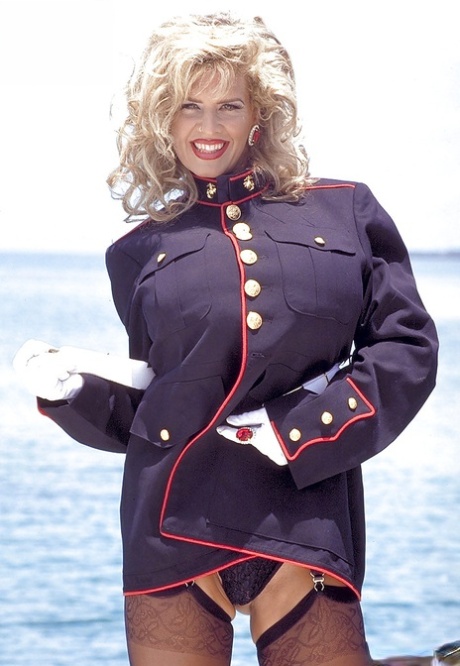 Older blonde babe Busty Dusty freeing huge boobs from uniform outdoors