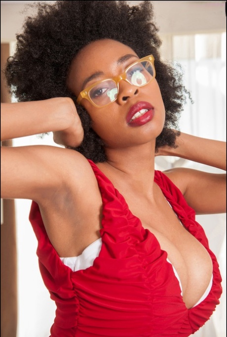 Ravishing ebony babe in glasses uncovering her massive boobs